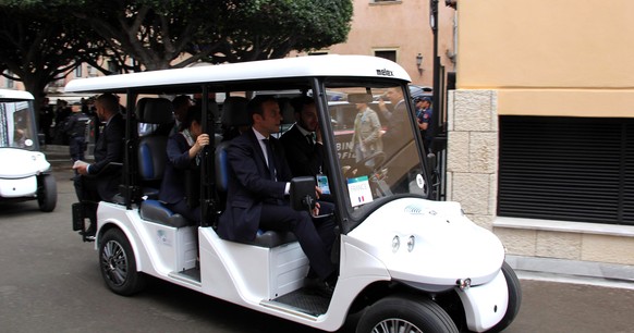 epa05991834 French President Emmanuel Macron (R) sits on a golf cart on the way to vist the Ancient Greek Theater of Taormina on the sideline of the G7 Summit in Taormina, Sicily island, Italy, 26 May ...