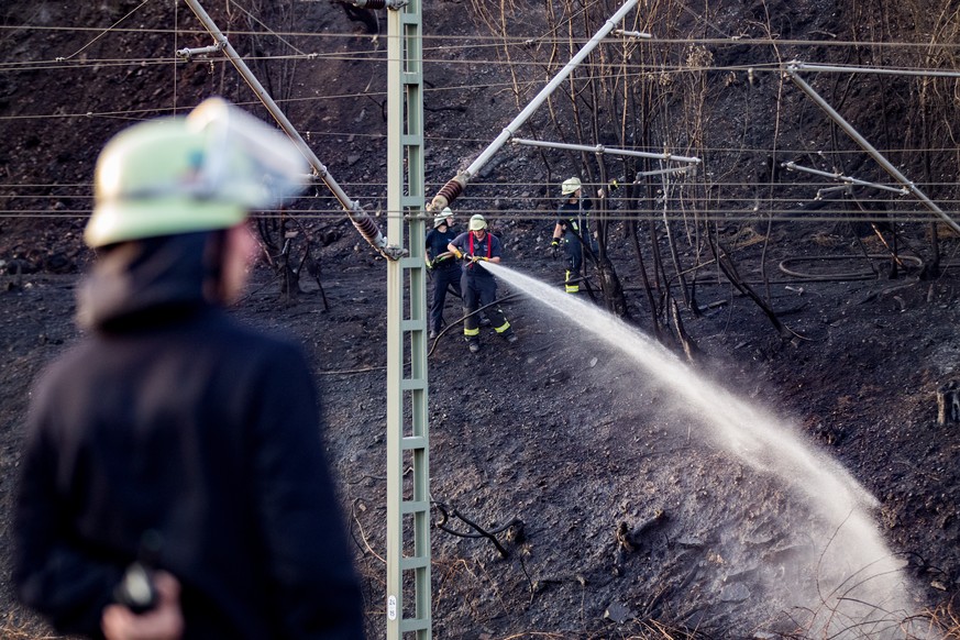 07.08.2018: Nordrhein-Westfalen, Siegburg: Feuerwehrleute loeschen eine Boeschung an der Bahnstrecke. Durch einen Boeschungsbrand waren mehrere Haeuser direkt an der wichtigen Bahnstrecke Koeln-Frankf ...