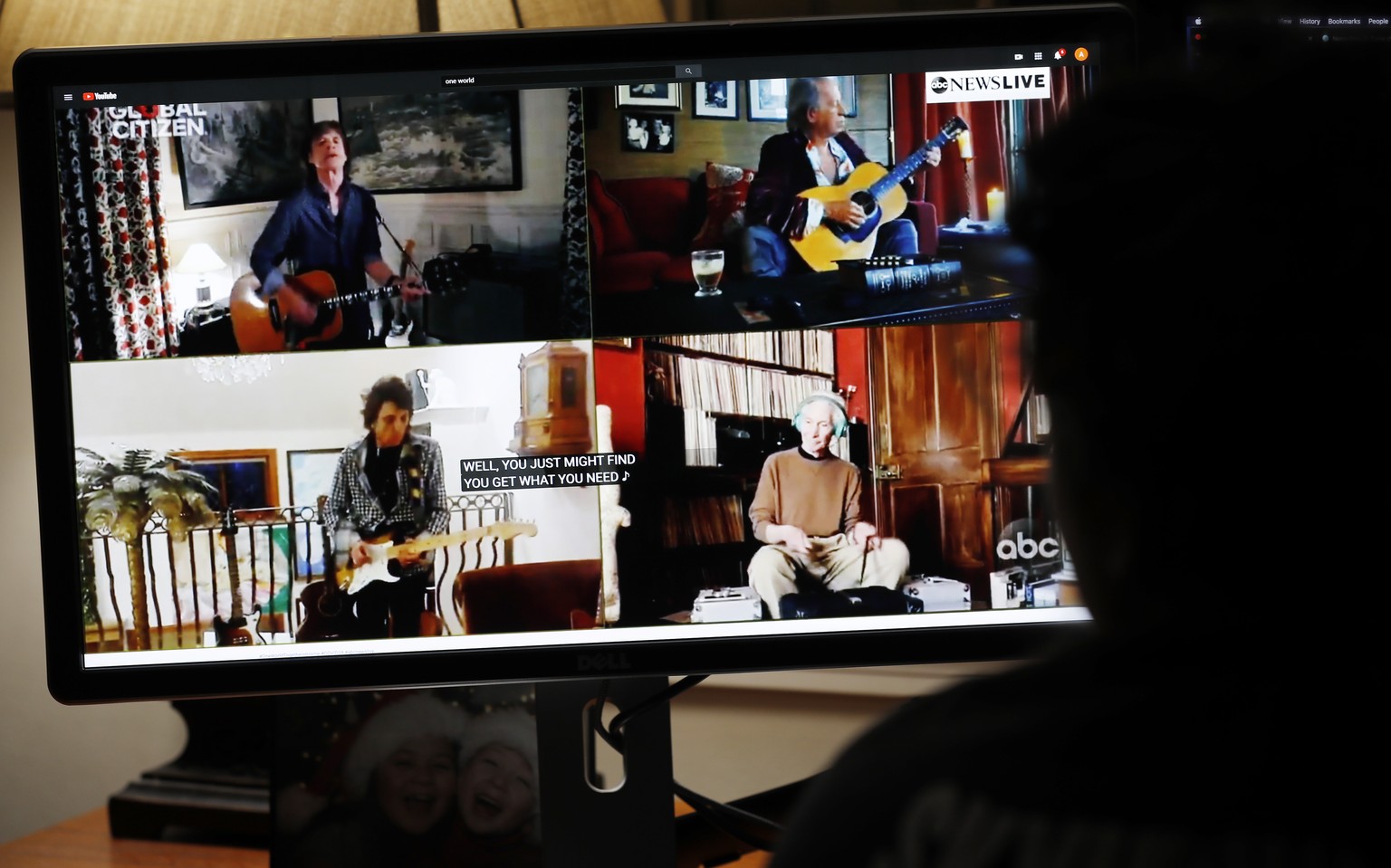 epa08371429 College sophomore Abby Campbell works on homework via remote learning as she watches US band The Rolling Stones perform during the One World: Together At Home broadcast in Norfolk, Massach ...