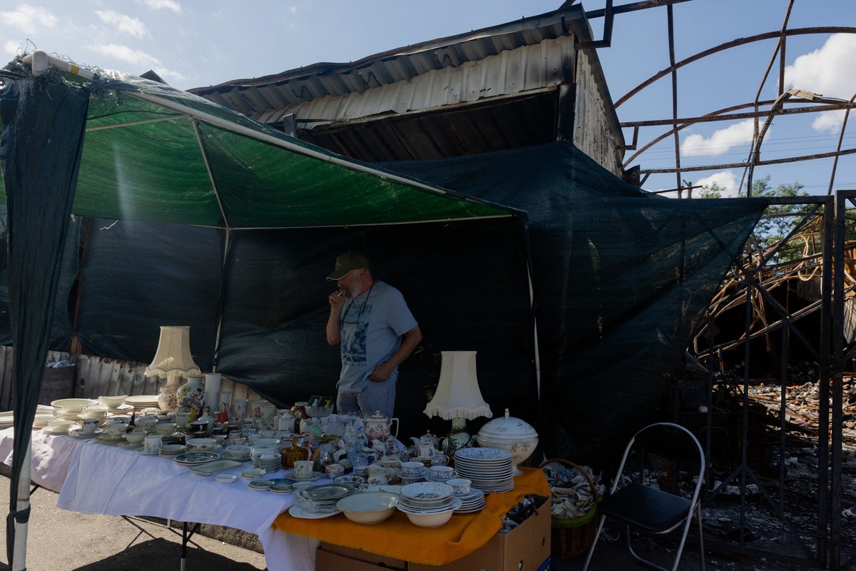 (FILES) Vadym, a 72-year-old vendor, sells goods that survived the shelling at a damaged street market following strikes in Petrivka neighbourhood in Kyiv on August 9, 2026, amid the Russian invasion  ...