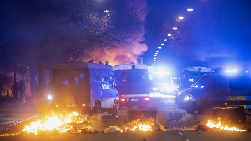 Police on buses try to break up the crowd as a city bus burns on a street in Malmo, Sweden, Saturday, April 16, 2022. Unrest broke out in southern Sweden late Saturday despite police moving a rally by ...