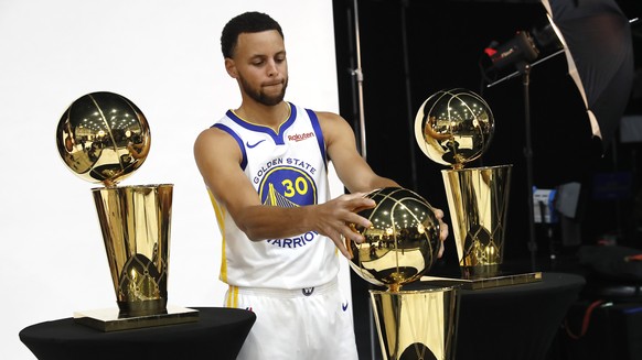 epa07044468 Golden State Warriors guard Stephen Curry poses with the NBA championship trophies during the NBA Golden State Warriors Media Day at the Rakuten Performance Center practice facility in Oak ...