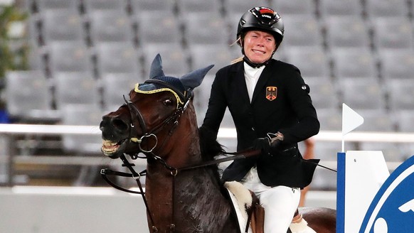 epa09400054 Annika Schleu of Germany on Saint Boy after hitting an obstacle as they compete in the Show Jumping portion of the Modern Pentathlon event at the Tokyo 2020 Olympic Games at the Tokyo Stad ...