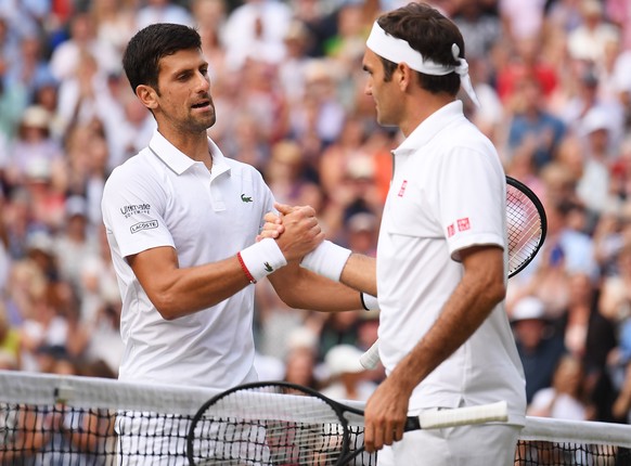 epa07717344 Novak Djokovic (L) of Serbia celebrates winning against Roger Federer (R) of Switzerland during their Men&#039;s final match for the Wimbledon Championships at the All England Lawn Tennis  ...