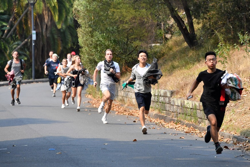 epa08095386 Members of the public run to secure positions at Mrs Macquarie&#039;s Chair on the eve of a New Year&#039;s fireworks display in Sydney, Australia, 31 December 2019. EPA/MICK TSIKAS AUSTRA ...