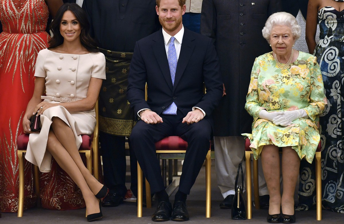 FILE - In this Tuesday, June 26, 2018 file photo Britain's Queen Elizabeth, Prince Harry and Meghan, Duchess of Sussex pose for a group photo at the Queen's Young Leaders Awards Ceremony at  ...