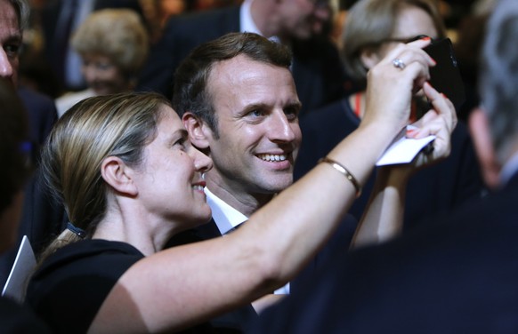 French President Emmanuel Macron takes a selfie with a woman as he opens the Frankfurt Book Fair in Frankfurt, Germany, Tuesday, Oct. 10, 2017. France is the partner country of this year&#039;s fair.  ...