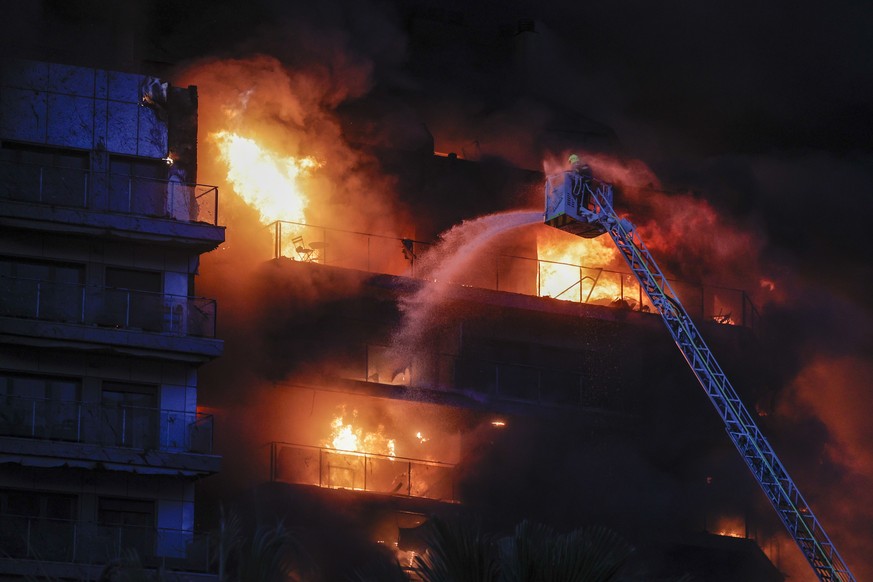 epa11173259 Firefighters try to extinguish a fire in a 14-storey residential building in Valencia, eastern Spain, February 22, 2024. The ongoing blaze injured at least seven people, and two people…