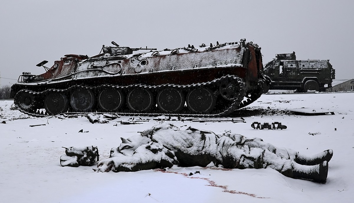 epaselect epa09784971 A soldier's lifeless body lies next to a burnt Russian APC after the Ukrainian army attacked it the previous day near the city of Kharkiv, Ukraine, 25 February 2022. Russian ...
