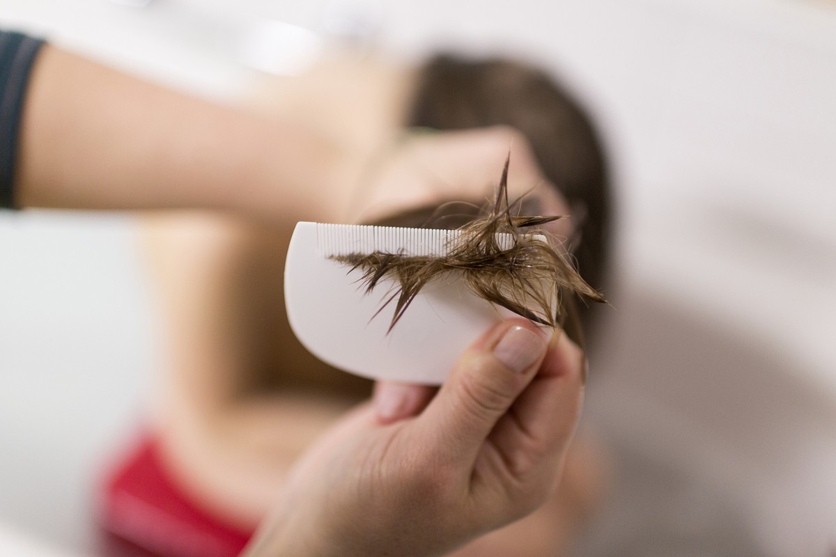 A mother uses a lice comb on her daughter's hair, pictured in Zurich, Switzerland, on February 25, 2014. (KEYSTONE/Gaetan Bally)