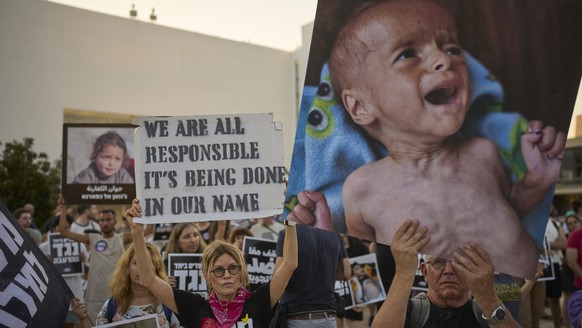 Israeli activists take part in a protest against the war in the Gaza Strip, Israel&#039;s measures regarding food distribution and the forced displacement of Palestinians, in Tel Aviv, Israel, Tuesday ...