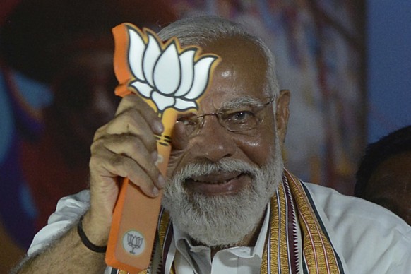 Indian Prime Minister Narendra Modi displays the Bharatiya Janata Party (BJP) symbol, lotus, during a road show while campaigning for national elections, in Chennai, India, Tuesday, April 9, 2024. (AP ...