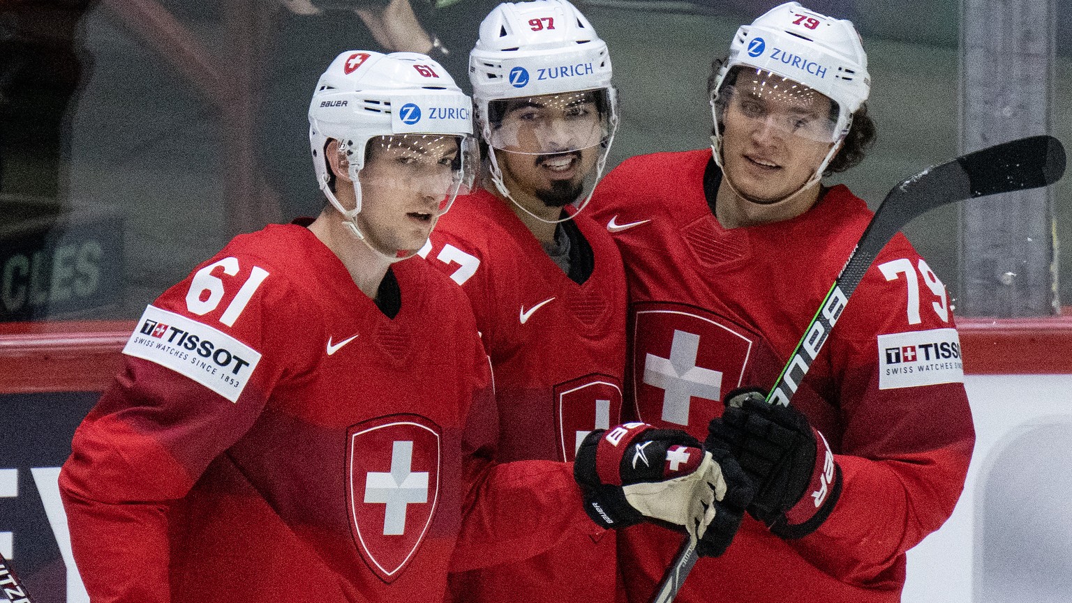 Switzerland&#039;s Fabrice Herzog, Jonas Siegenthaler and Calvin Thuerkauf, from left, celebrate the second goal during their Ice Hockey World Championship group A preliminary round match between Swit ...