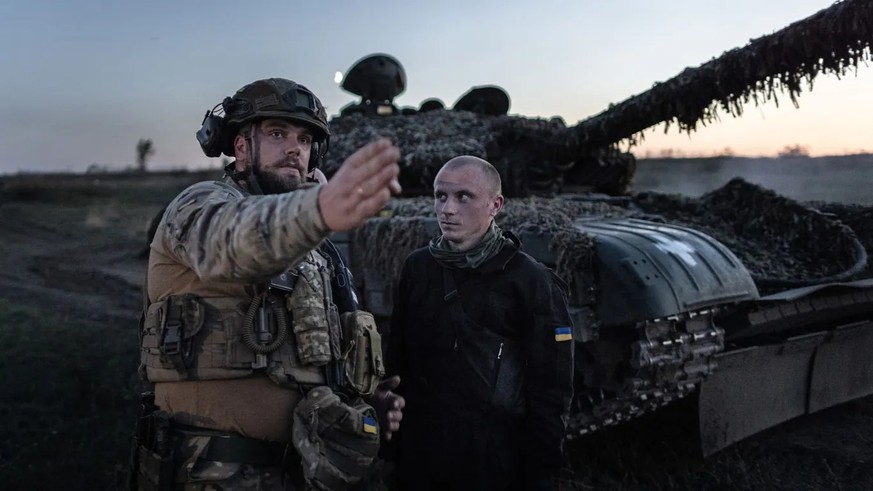 Die 22. Brigade der Ukraine: Ein kommandierender Soldat gibt bei einer Nachtschießübung vor einem T-72 Panzer Anweisungen.