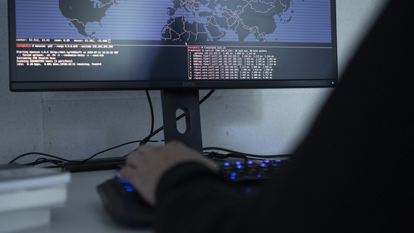 ZUM THEMA CYBERCRIME STELLEN WIR IHNEN HEUTE FOLGENDE SYMBOLBILDER ZUR VERFUEGUNG --- [Symbolic Image / Staged Image] A hacker is using a computer showing a Traceroute world map, photographed on July  ...