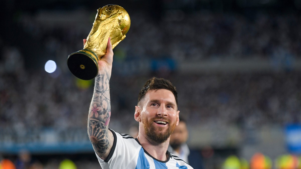 FILE - Argentina's Lionel Messi hoists the winning team replica of the FIFA World Cup trophy during a celebration ceremony for local fans after an international friendly soccer match against Pana ...