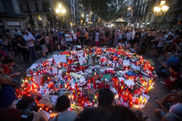 epa06150561 People pay tribute to victims in Canaletas square, in Barcelona, Spain, 18 August 2017. According to media reports, at least 14 people have died and 130 were injured when a van crashed int ...