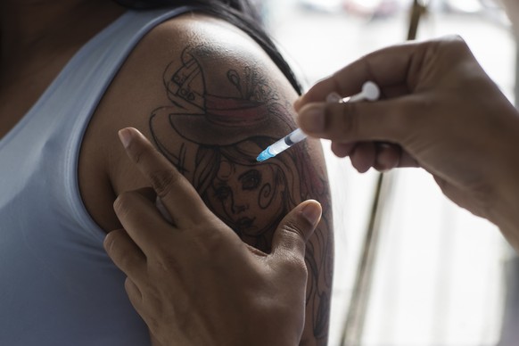 A woman gets a shot of the Pfizer vaccine for COVID-19 during a vaccination campaign for women over age 31 in Sao Joao de Meriti, Brazil, Wednesday, Aug. 11, 2021. (AP Photo/Bruna Prado)