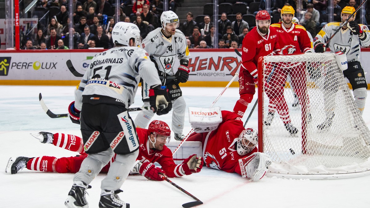 L'attaquant fribourgeois David Desharnais, gauche, marque le deuxieme but au gardien lausannois Tobias Stephan, centre, lors de la rencontre du championnat suisse de hockey sur glace de National  ...