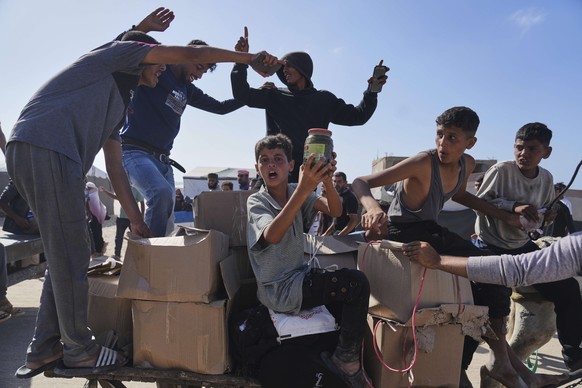 Palestinians carry boxes containing food and humanitarian aid packages delivered by the Gaza Humanitarian Foundation, a U.S.-backed organization approved by Israel, in Rafah, southern Gaza Strip, on T ...