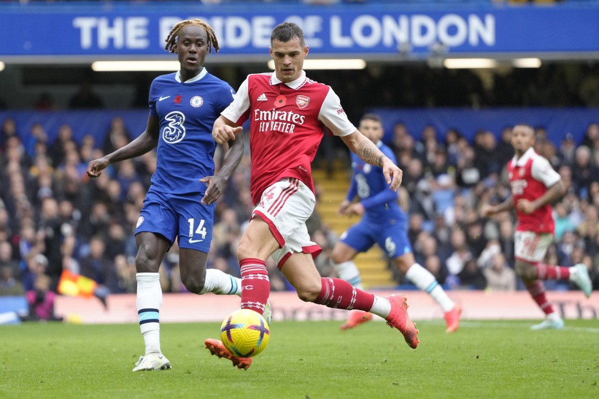 Arsenal's Granit Xhaka, centre, and Chelsea's Trevoh Chalobah challenge the ball during the English Premier League soccer match between Chelsea and Arsenal at Stamford Bridge Stadium in Lond ...
