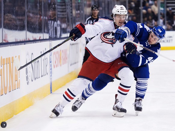 Dean Kukan (l.) behauptet sich in einem NHL-Spiel gegen Tobias Lindberg von den Toronto Maple Leafs.