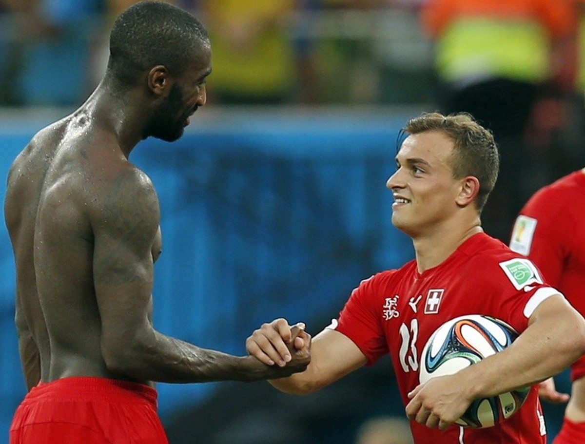 epa04282028 Switzerland's Xherdan Shaqiri (C) and Johan Djourou (L) celebrate with the fans after winning the FIFA World Cup 2014 group E preliminary round match between Honduras and Switzerland  ...