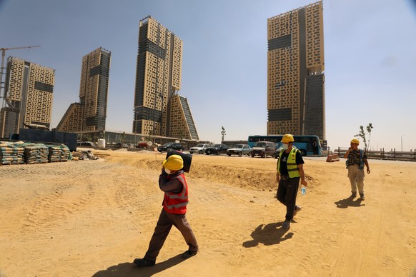 epa10180125 Egyptian laborers work at a construction site in the Central Business District (CBD) of the New Administrative Capital (NAC), some 45km east of Cairo, Egypt, 12 September 2022. The constru ...