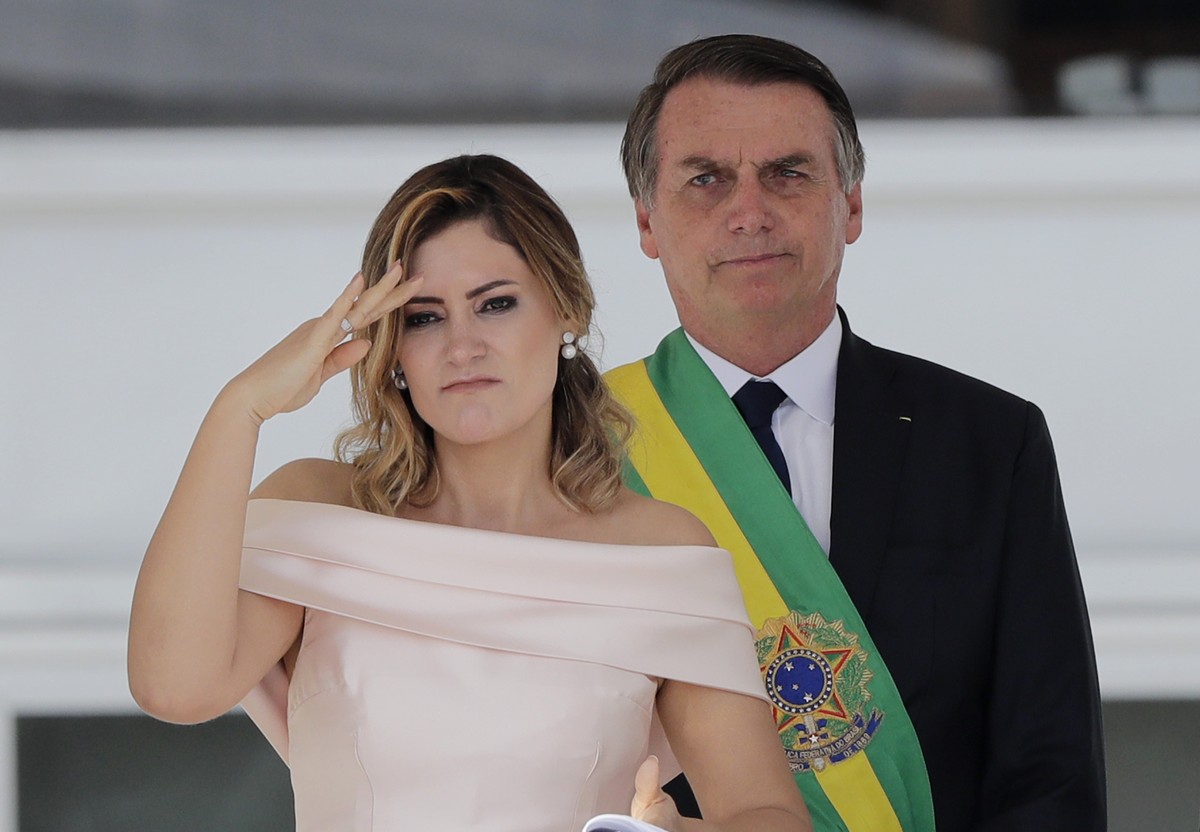 CORRECTS TO SAY SHE IS SPEAKING SIGN LANGUAGE, NOT SALUTING - Brazil's new first lady Michelle Bolsonaro uses sign language to speak to the public, as her husband, President Jair Bolsonaro, stand ...