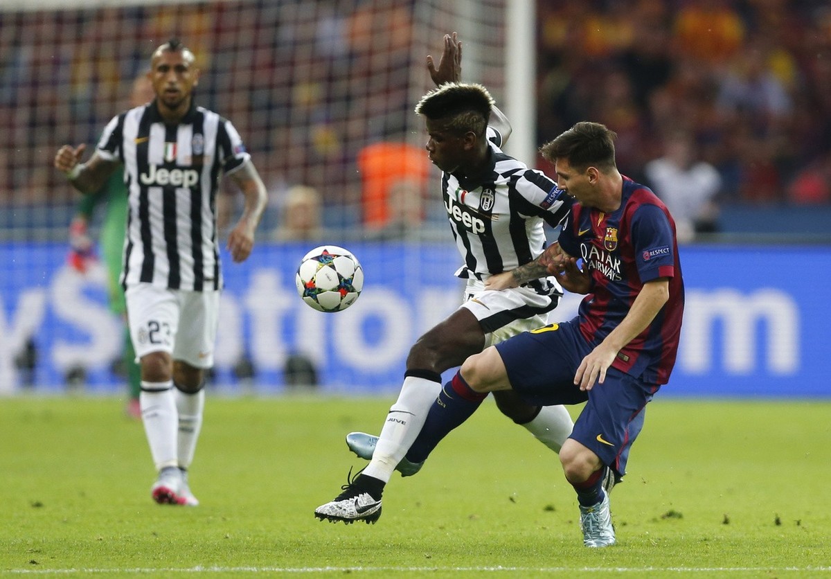 Juventus' Paul Pogba, centre, battles for the ball with Barcelona's Lionel Messi during the Champions League final soccer match between Juventus Turin and FC Barcelona at the Olympic stadium ...