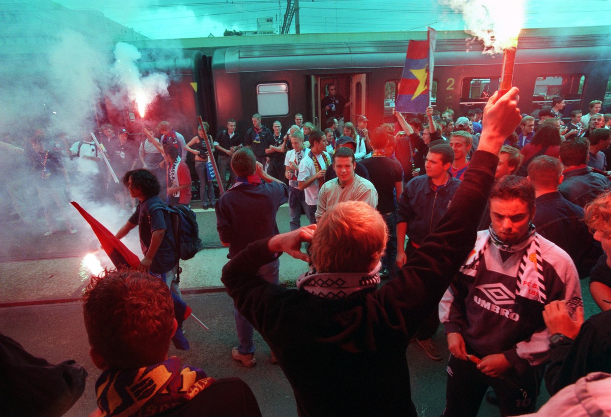 ARCHIV - Fans des FC Basels formieren sich zu einer Gruppe und zuenden auf einem Bahnhof Fackeln an, aufgenommen am 26. August 2003. - Das Parlament will Sportfans vorderhand nicht per Gesetz zwingen, ...