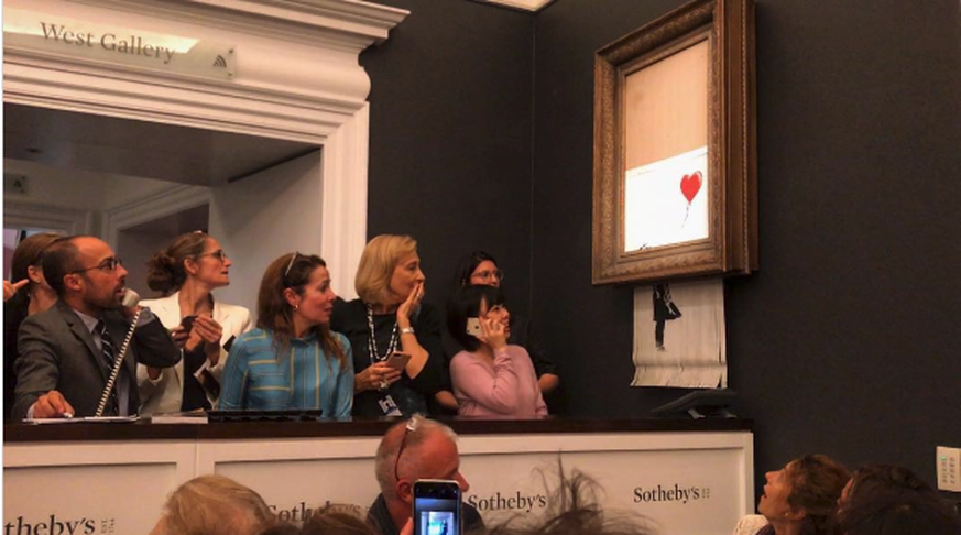 Verdutzte Zuschauer bei der Sotheby's Auktion: Soeben wurde Banksys Bild geschreddert.&nbsp;