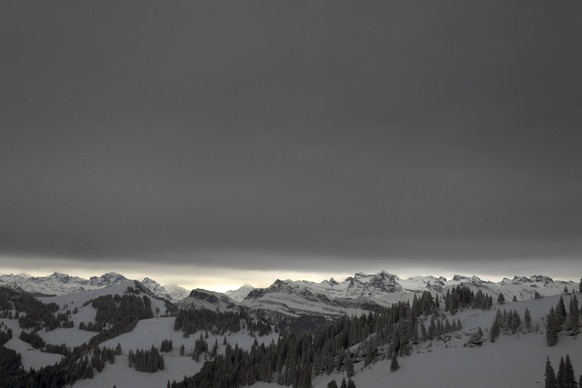 Das Alpenpanorama unter dunkler Wolkendecke in Kloesterli, aufgenommen am Montag, 29. Dezember 2014. (KEYSTONE/GAETAN BALLY)