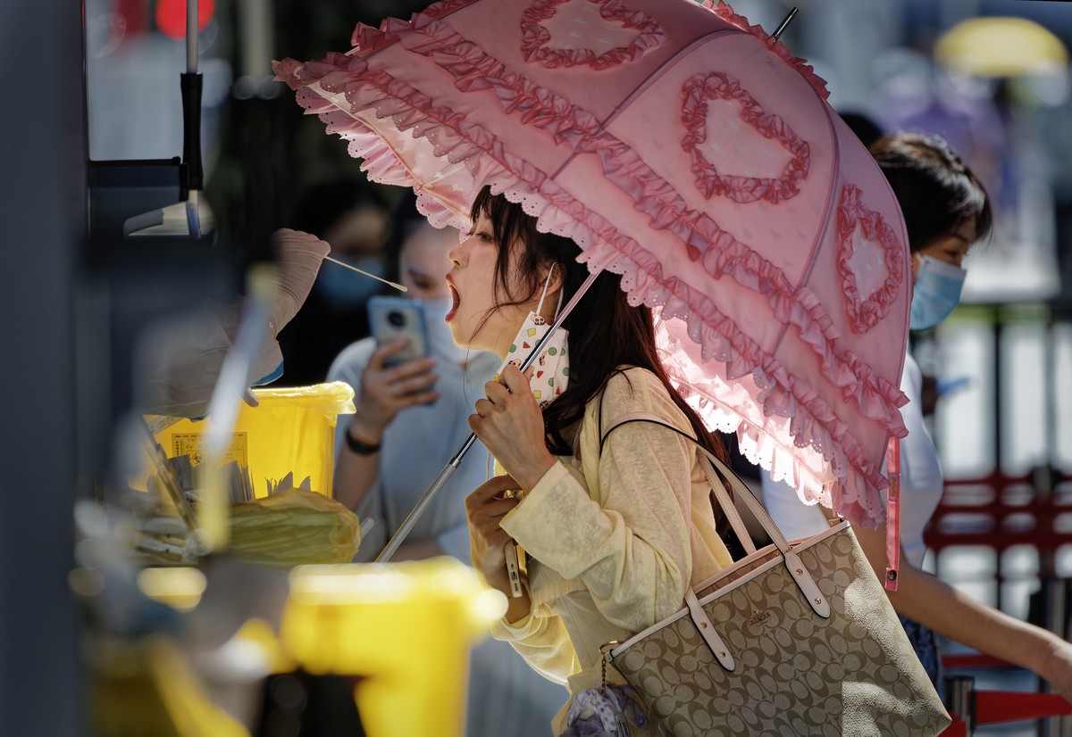 epaselect epa10105383 A woman takes Coronavirus PCR test on the street, in Shanghai, China, 04 August 2022. Shanghai continues PCR mass testing to control community transmission of COVID-19. Shanghai  ...