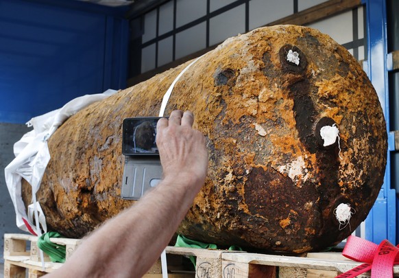 A journalist takes a photo of a defused 1.8 ton WWII bomb in Frankfurt, Germany, Sunday, Sept. 3, 2017. Police say bomb disposal experts have successfully defused a huge World War II-era bomb in the G ...