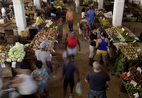 FILE - Customers shop at an open-air market in Havana, Cuba, Dec. 3, 2013. Cuban authorities put price caps on various staple products Tuesday, July 9, 2024, aiming to lower inflation. (AP Photo/Frank ...
