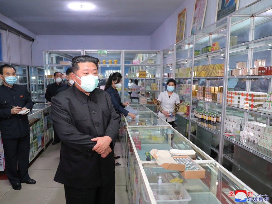 epa09950076 A photo released by the official North Korean Central News Agency (KCNA) shows North Korean leader Kim Jong-un (C) wearing a face mask while inspecting a pharmacy in Pyongyang, North Korea ...