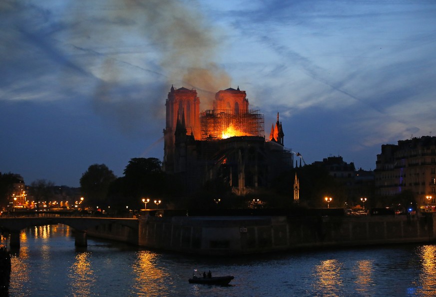 Firefighters tackle the blaze as flames and smoke rise from Notre Dame cathedral as it burns in Paris, Monday, April 15, 2019. Massive plumes of yellow brown smoke is filling the air above Notre Dame ...