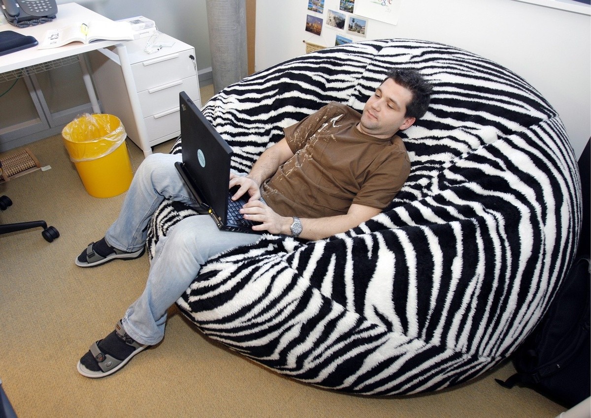 An employee of Google works in a beanbag beside his desk during the official opening day of the new Google Engeneering center in Zurich, Switzerland, Thursday, March 6, 2008. (KEYSTONE/Walter Bieri)

 ...