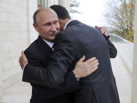FILE - In this Nov. 20, 2017, photo, Russian President Vladimir Putin, left, embraces Syrian President Bashar Assad in the Bocharov Ruchei residence in the Black Sea resort of Sochi, Russia. (Mikhail  ...