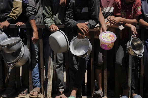 Holding their pots, Palestinians wait to get donated food at a community kitchen in Khan Younis, southern Gaza Strip, Monday, June 2, 2025. (AP Photo/Abdel Kareem Hana)
Israel Palestinians
