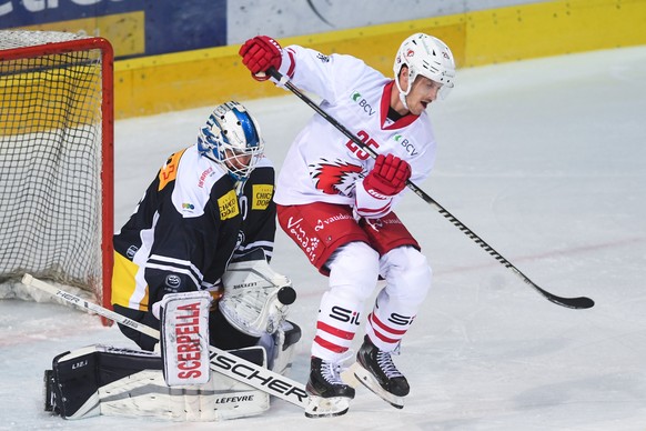Ambri&#039;s goalkeeper Damiano Ciaccio, left, and Lausanne&#039;s player Cory Emmerton, during the preliminary round game of National League A (NLA) Swiss Championship 2020/21 between HC Ambri Piotta ...