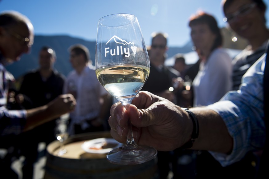 Des personnes boivent du vin lors de la 20eme edition de la Fete de la Chataigne ce samedi 18 octobre 2014 a Fully en Valais. (KEYSTONE/Jean-Christophe Bott)