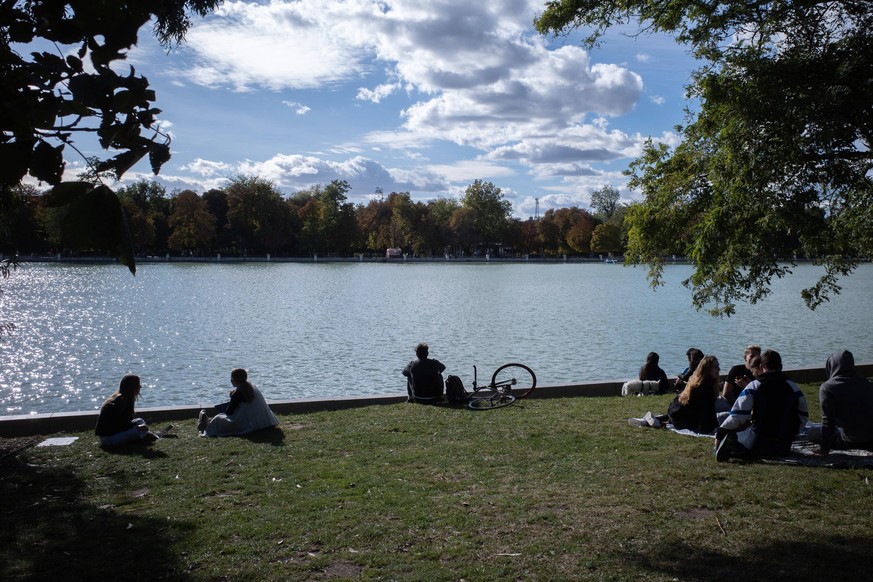 201005 -- MADRID, Oct. 5, 2020 -- People sit on a lawn at the El Retiro park in Madrid, Spain on Oct. 4, 2020. SPAIN-MADRID-PARK-DAILY LIFE MengxDingbo PUBLICATIONxNOTxINxCHN