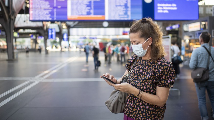 Pendler mit Atemschutzmasken bewegen sich auf dem Hauptbahnhof in Zuerich, aufgenommen am Montag, 6. Juli 2020. (KEYSTONE/Ennio Leanza)