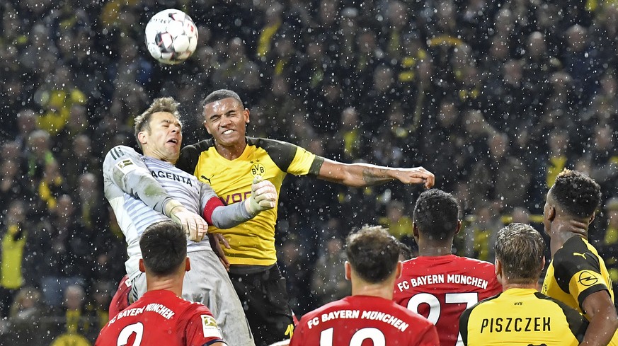 Dortmund&#039;s Manuel Akanji and Bayern goalkeeper Manuel Neuer, left, challenge for the ball during the German Bundesliga soccer match between Borussia Dortmund and Bayern Munich in Dortmund, German ...