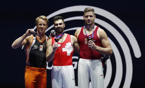 Oliver Hegi of Switzerland, center, celebrates after winning the gold medal on the horizontal bar during the men&#039;s artistic gymnastics finals at the European Championships in Glasgow, Scotland, S ...