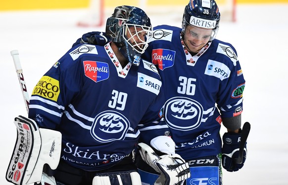 Ambri&#039;s goalkeeper Sandro Zurkirchen, left, and Ambri&#039;s player Matt D&#039;Agostini, right, celebrate their victory after penalty shot during the preliminary round game of National League A  ...