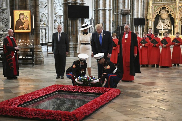 U.S President Donald Trump, accompanied by his wife Melania and Britain's Prince Andrew, center left, places a wreath on the Grave of the Unknown Warrior during a tour of Westminster Abbey in central  ...