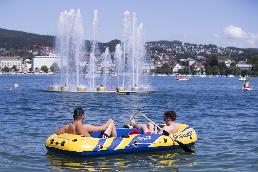 Zwei junge Maenner geniessen das schoene Sommerwetter im Schlauboot auf dem Zuerichsee beim Hafen Enge am Dienstag, 19. Juli 2016, in Zuerich. (KEYSTONE/Patrick B. Kraemer)